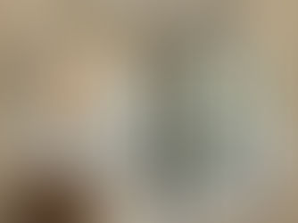 Modern bathroom with a wooden vanity, oval mirror, black faucet, glass shower with black frame, and toilet.