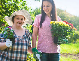 participant with disability and support worker gardening together