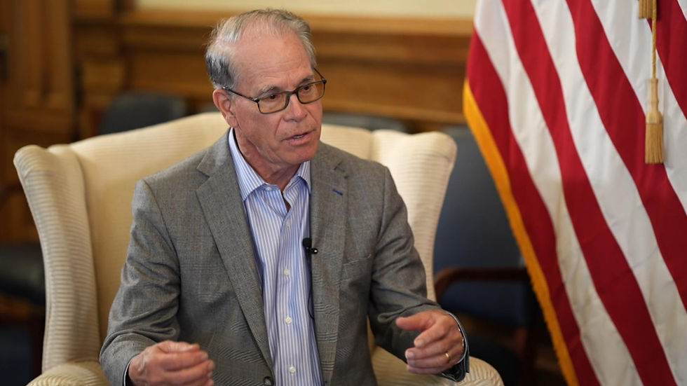 Governor Mike Braun sitting in the governor's office, next to an American flag - photo credit: WTHR