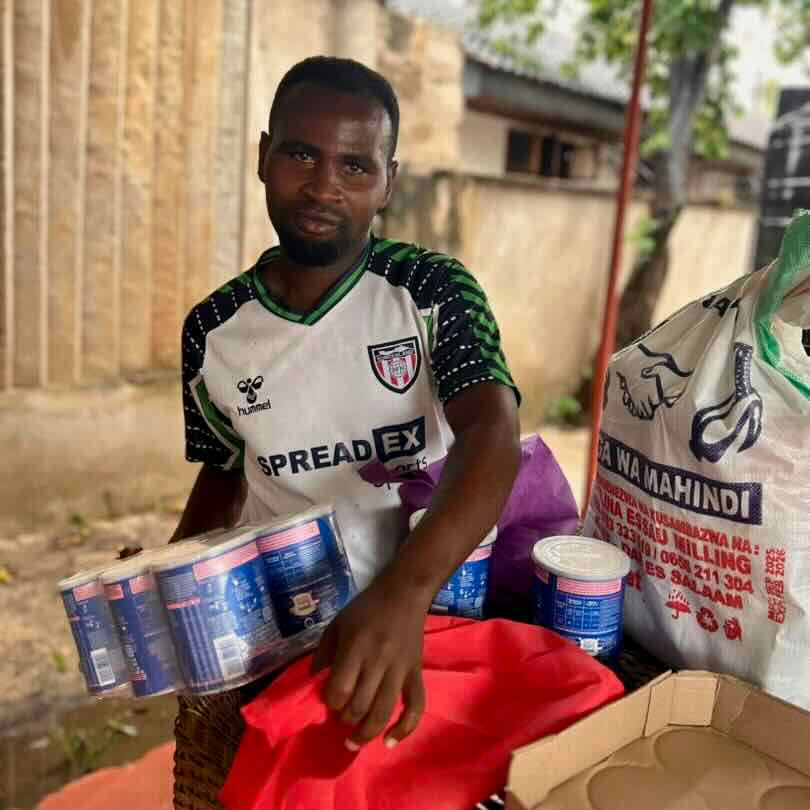 Father collecting infant formula from Kulea Villages in Tanzania during post-election unrest
