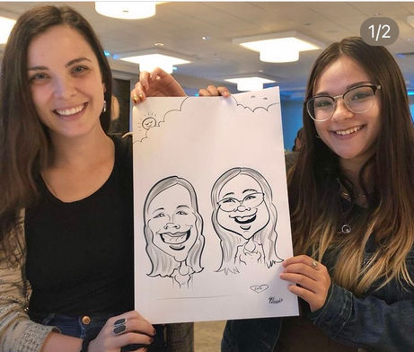 two ladies holding their caricature which is drawn in black and white