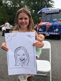 a little girl smiling and holding her caricature