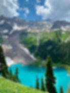 “Landscape photograph ‘Jewell Lake’ by Christy Cones, showing a vivid turquoise alpine lake near Yankee Boy Basin in Colorado, framed by snowfields, rock slides, and evergreen forest.”