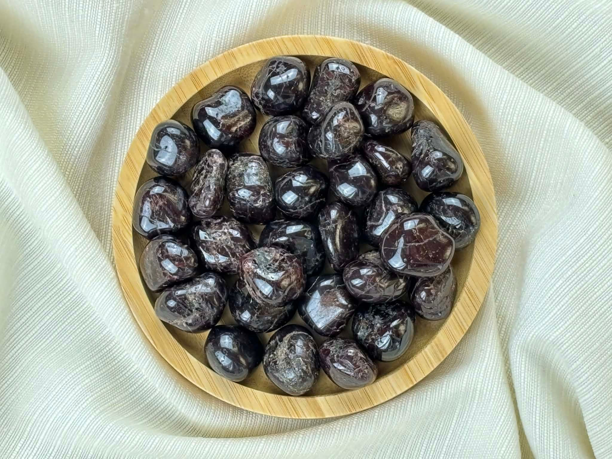 Pierre roulée grenat naturel dans un bol en bois