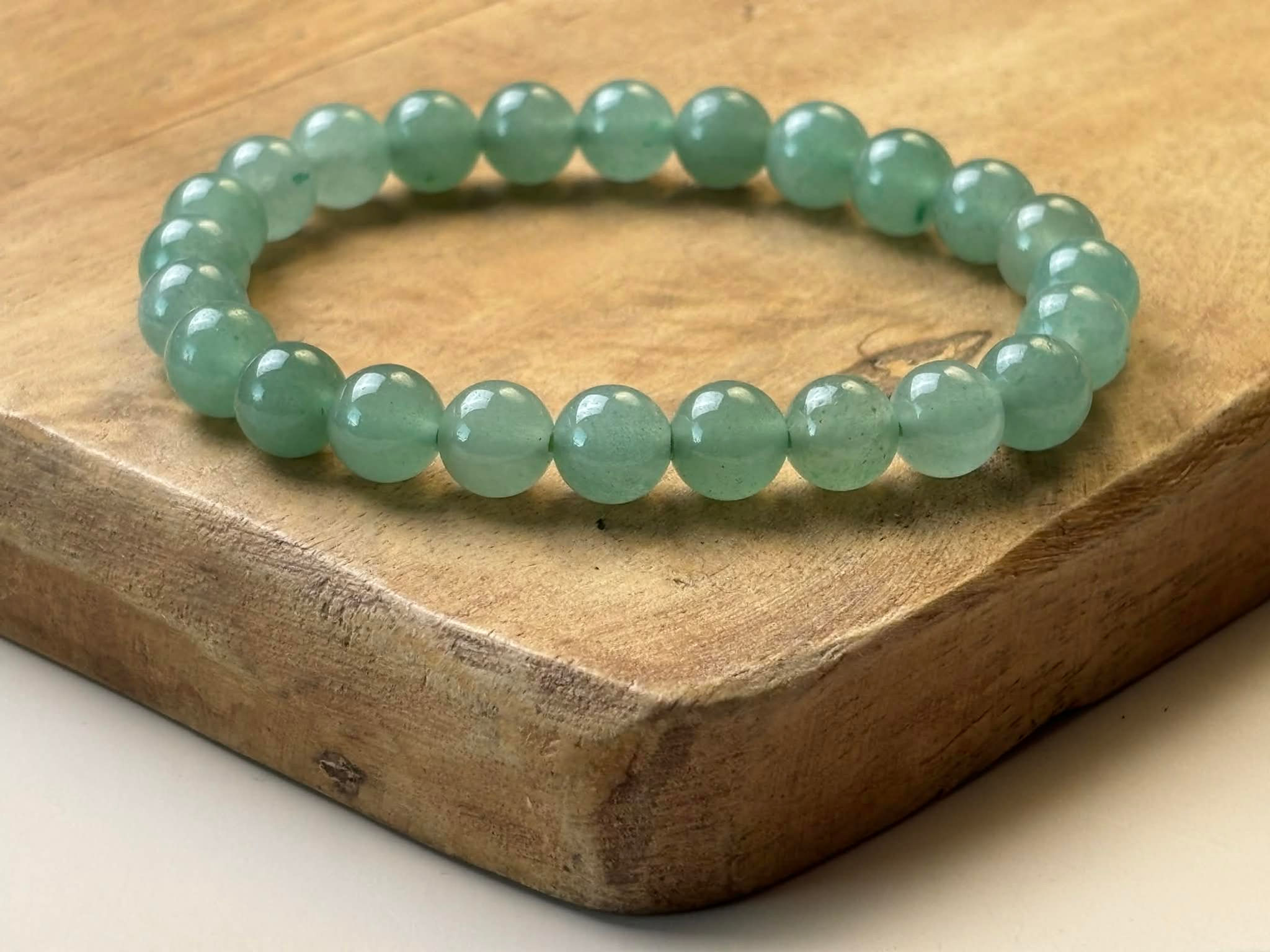 Bracelet en aventurine verte sur un plateau en bois