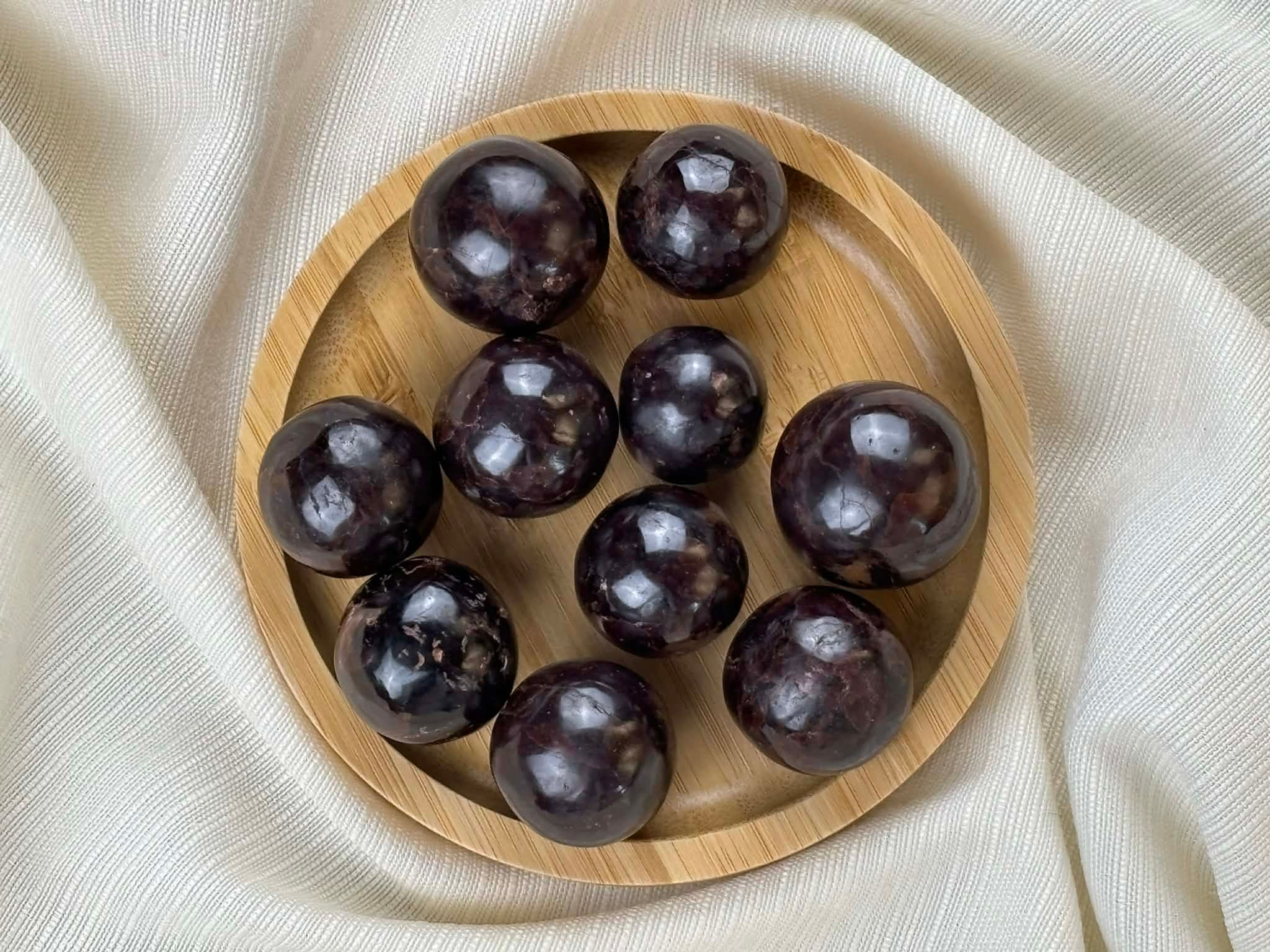 Grenat en pierre roulée ronde qualité extra dans un bol en bois naturel