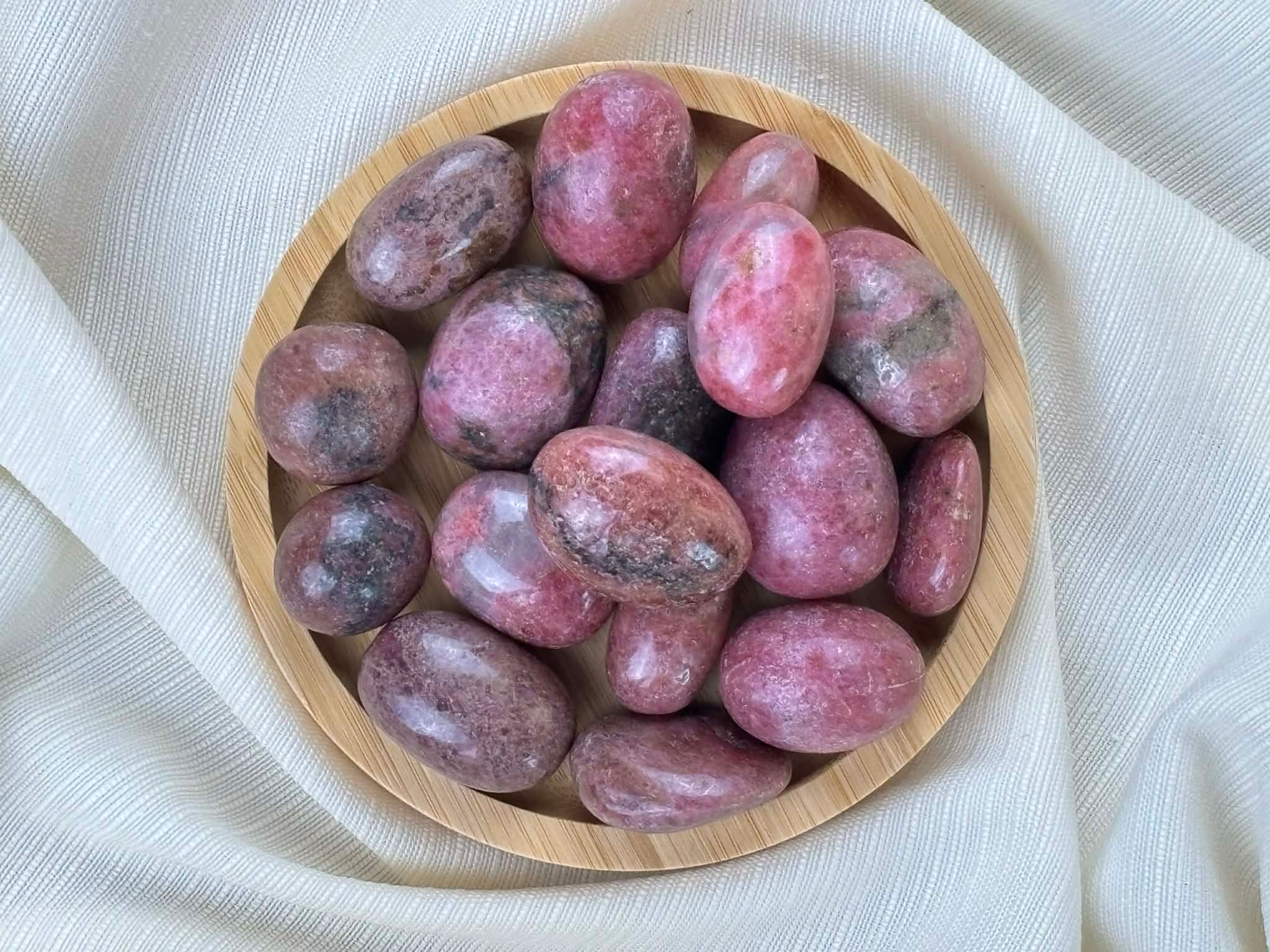 Rhodonite roulée qualité AA+ dans un bol en bois naturel