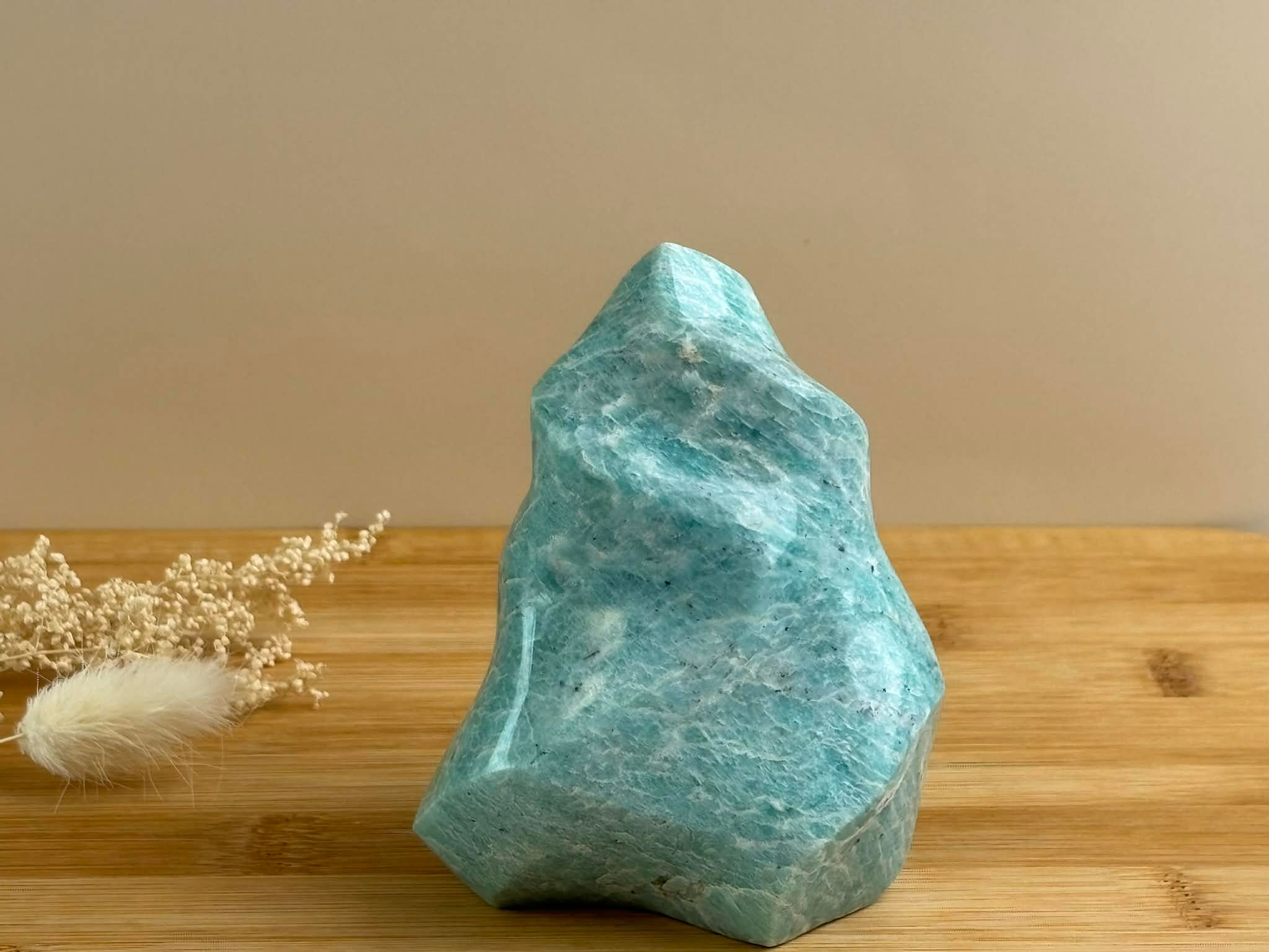 Amazonite en forme de flamme sur un plateau en bois