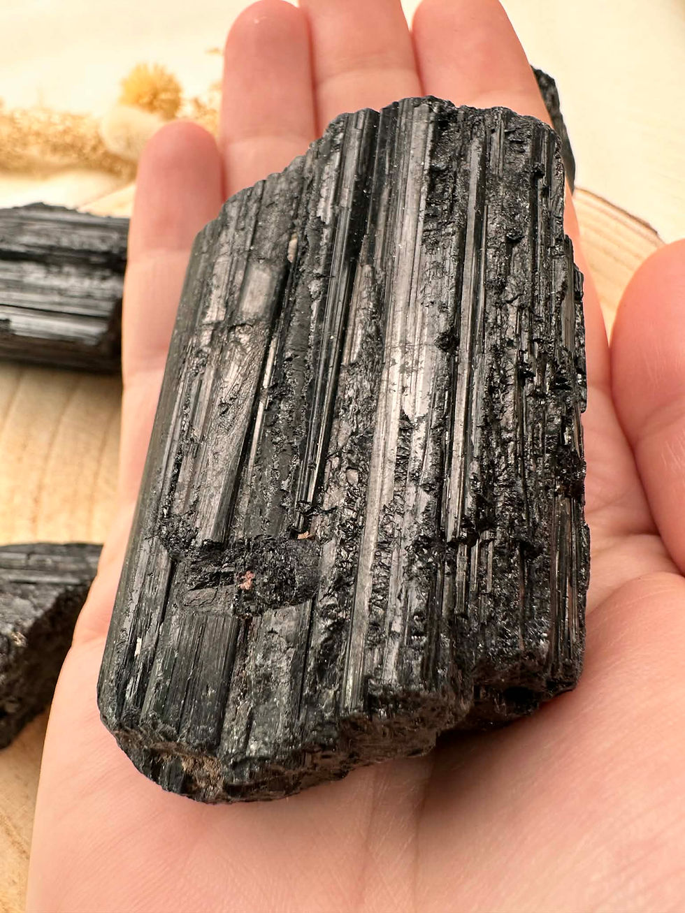 Miniature : Tourmaline noire brute tenue dans la main zoom sur les détails