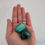 Miniature : Malachite pierre roulée taille 2 à 4 cm présentée dans la main