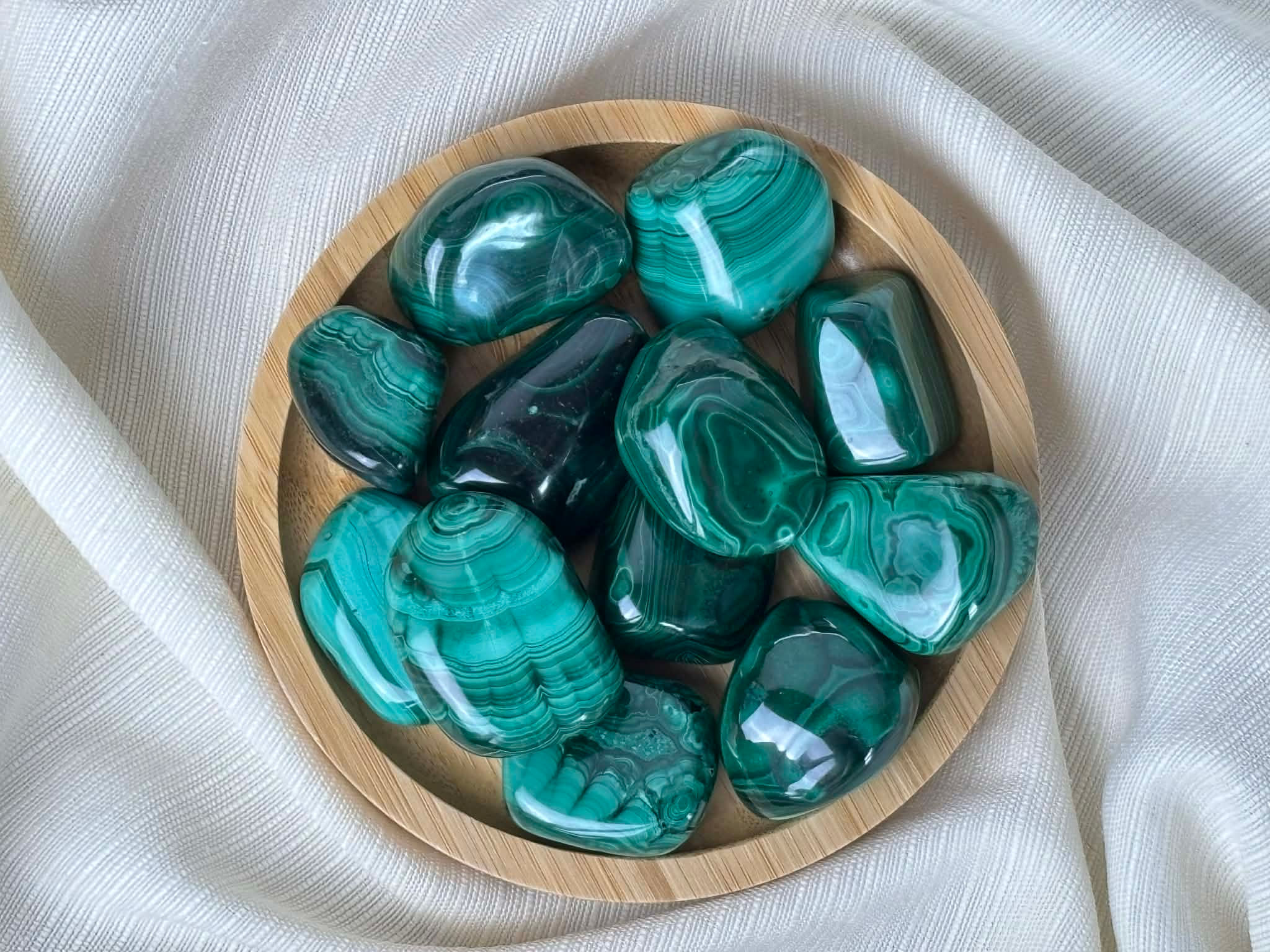 Malachite en pierre roulée naturelle dans un bol en bois