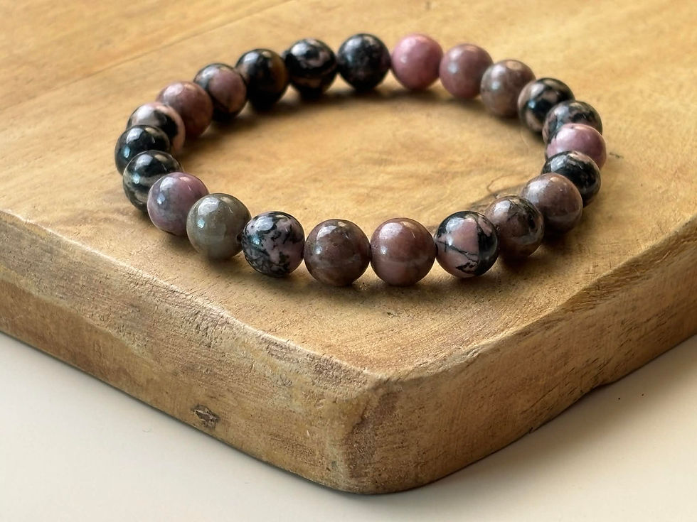 Bracelet en Rhodonite sur un plateau en bois
