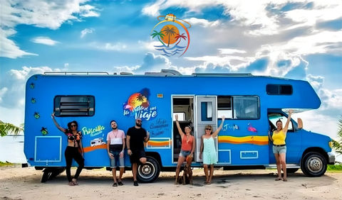 groupe de personnes heureuse devant un camping-car bleu au mexique
