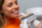 Smiling woman's teeth color-matched for dental procedure