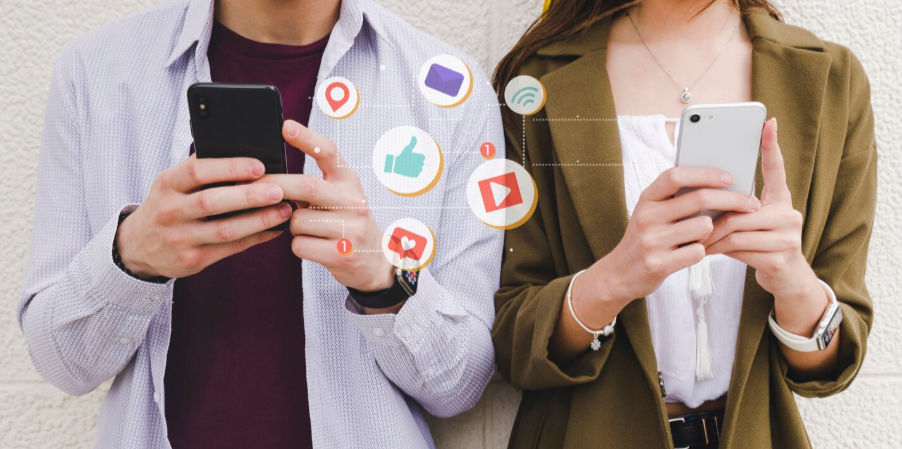 Duas pessoas a utilizar os seus telemóveis e a utilizar redes sociais.