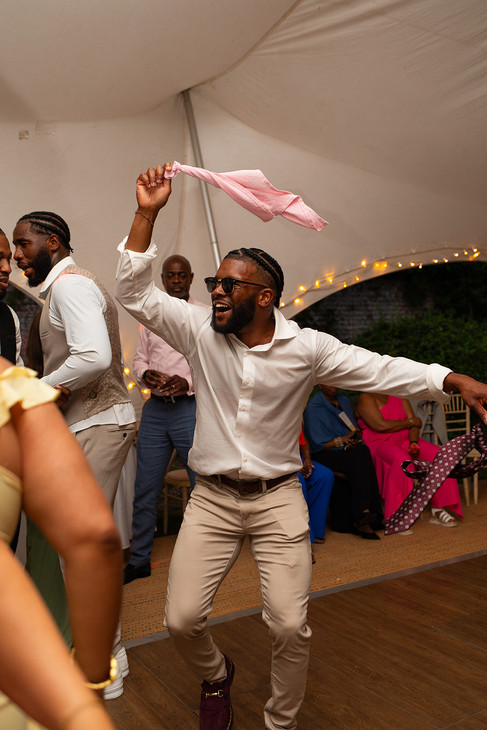 Groomsman dancing with a napkin in the wedding marquee