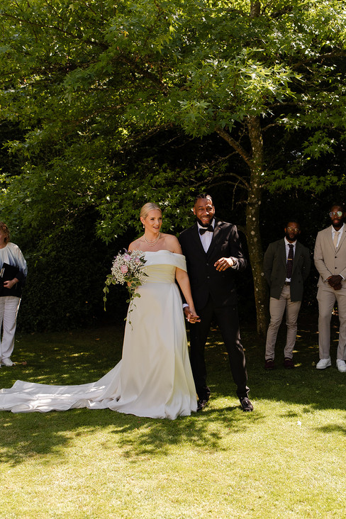 Iona and Darren laugh together with their guests around them.