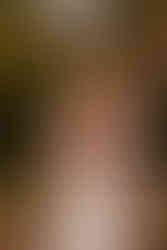 Groom embraces the bride in a bear hug in the middle of a garden.