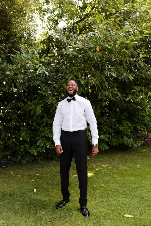Groom laughing whilst getting ready outside.