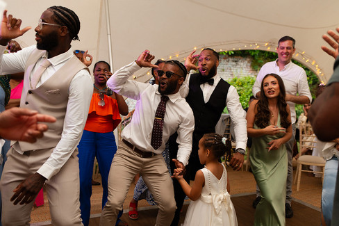 Darren and his wedding guests dancing together in the wedding marquee.