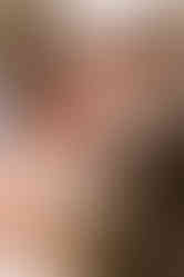 Groom pulling up the brides chin to pull her in for a kiss.