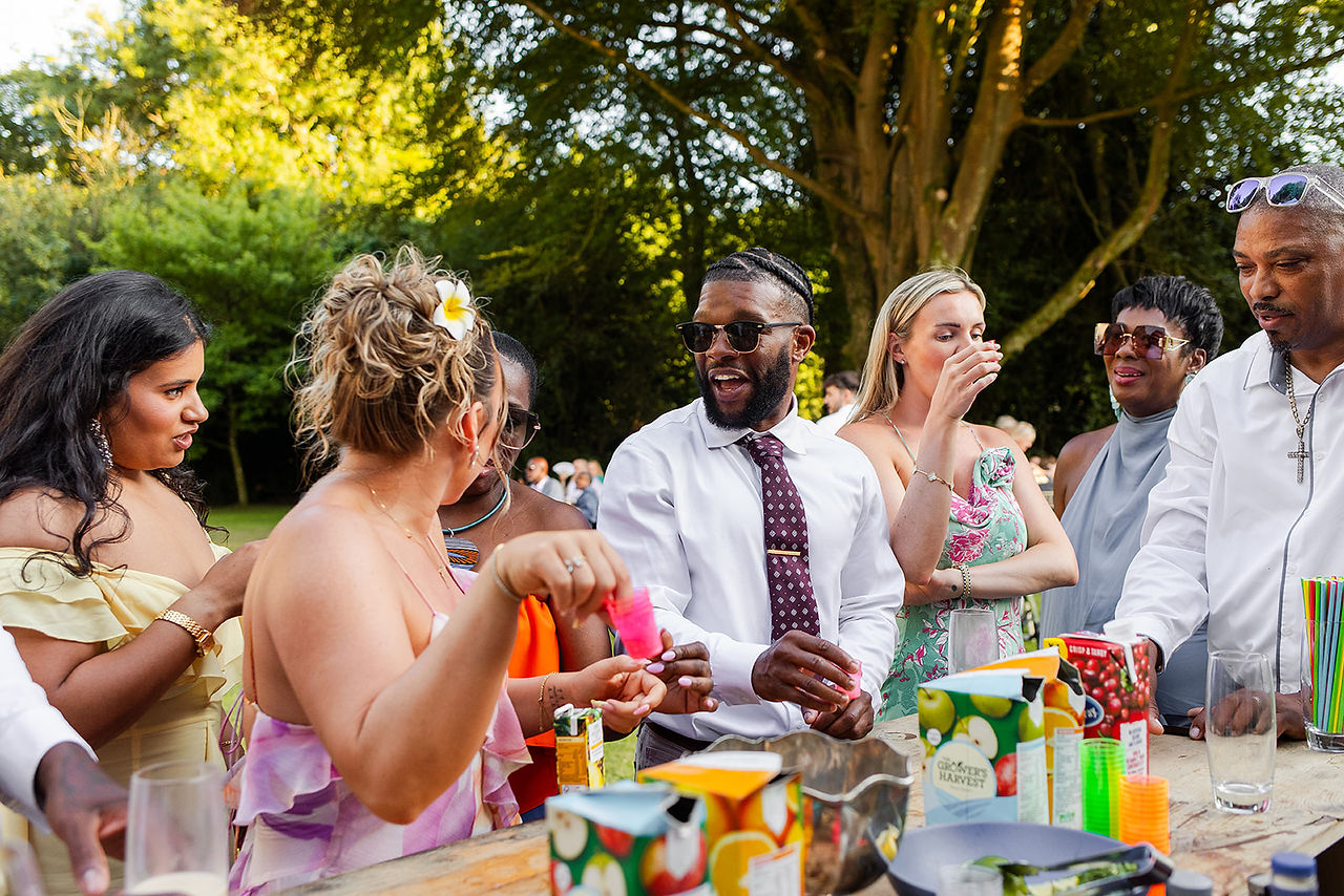 Guests laugh together whilst getting drinks