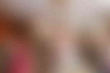 Bride smiling whilst holding holding the groom's hands at the ceremony.