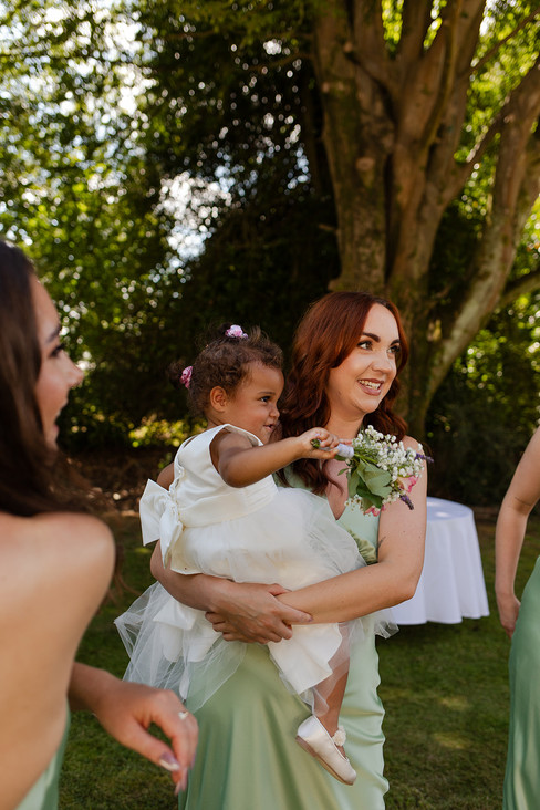 Bridesmaid holding the flower girl.