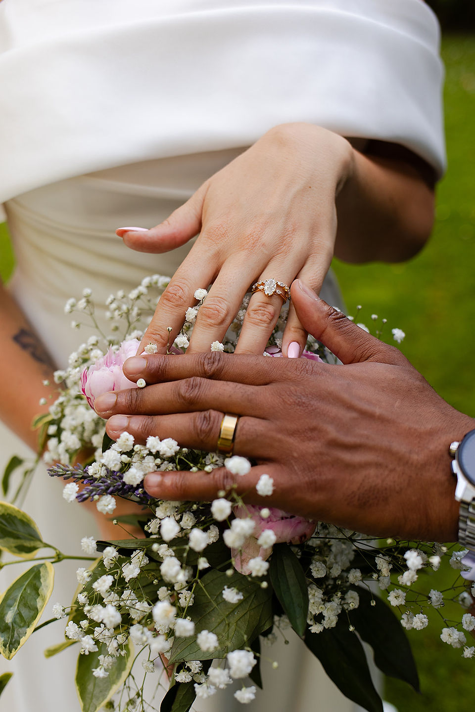 Close up of bride and grooms rings over the bouquet of flowers