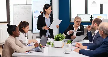 woman-secretary-bringing-documents-coffee-executive-director-while-multiethnic-team-planni