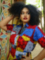 Beautiful model in traditional African print shirt with bold patterns, perfect for summer fashion.