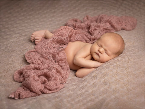 Nyfødt jente, rosa teppe, sovende på siden