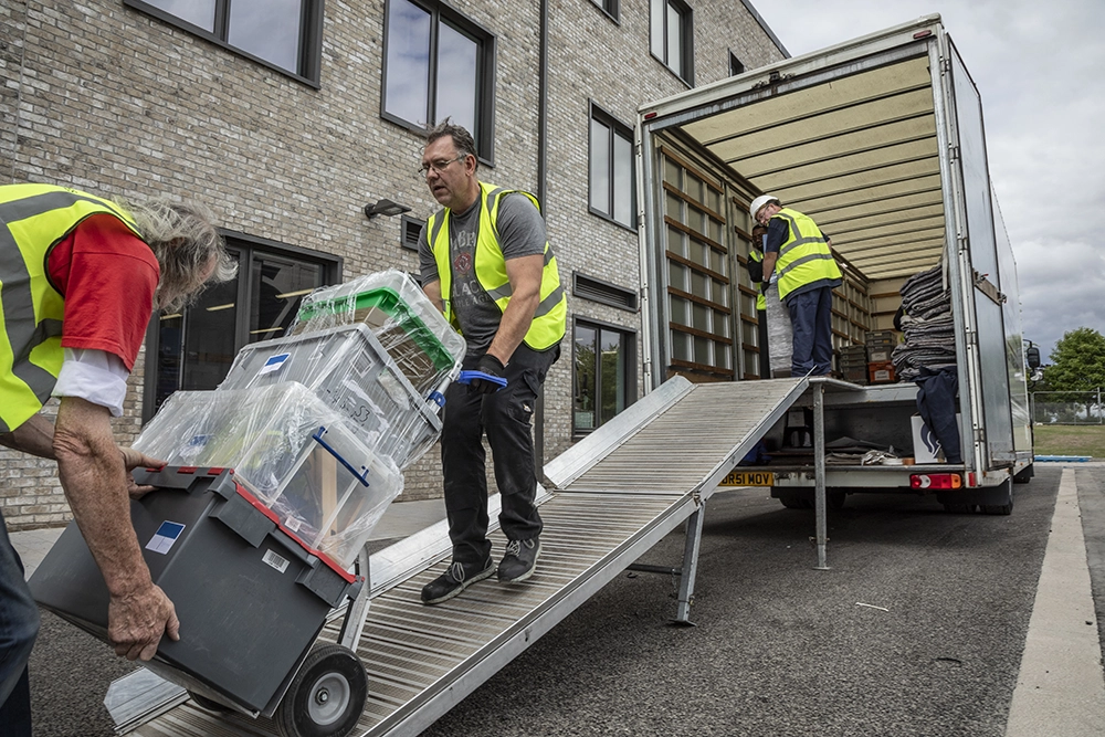 removal men removing crates from a van