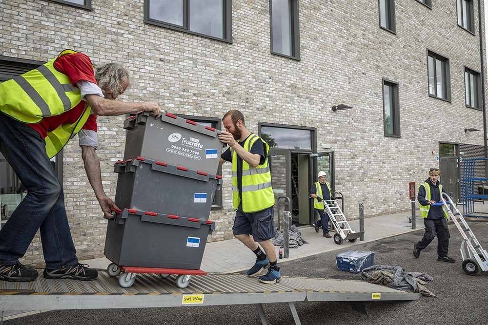 removal men removing crates from a van