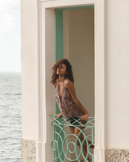 Arrosto is a classic shaped halter top, fully lined and featuring a deep cowl neckline. Intricate jewel-toned beading forms a floral design covering the top and adding a subtle shimmer. An elasticated, ruched back strap makes this easy to slip on, while the non-adjustable front fabric bar allows for graceful movement while keeping the top secured.