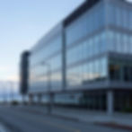 Modern glass building next to a waterfront road