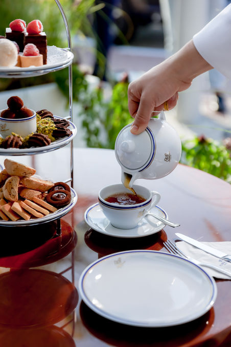 Afternoon tea service with fine Italian porcelain, biscotti, and assorted pastries, reflecting elegant hospitality and artisanal presentation.