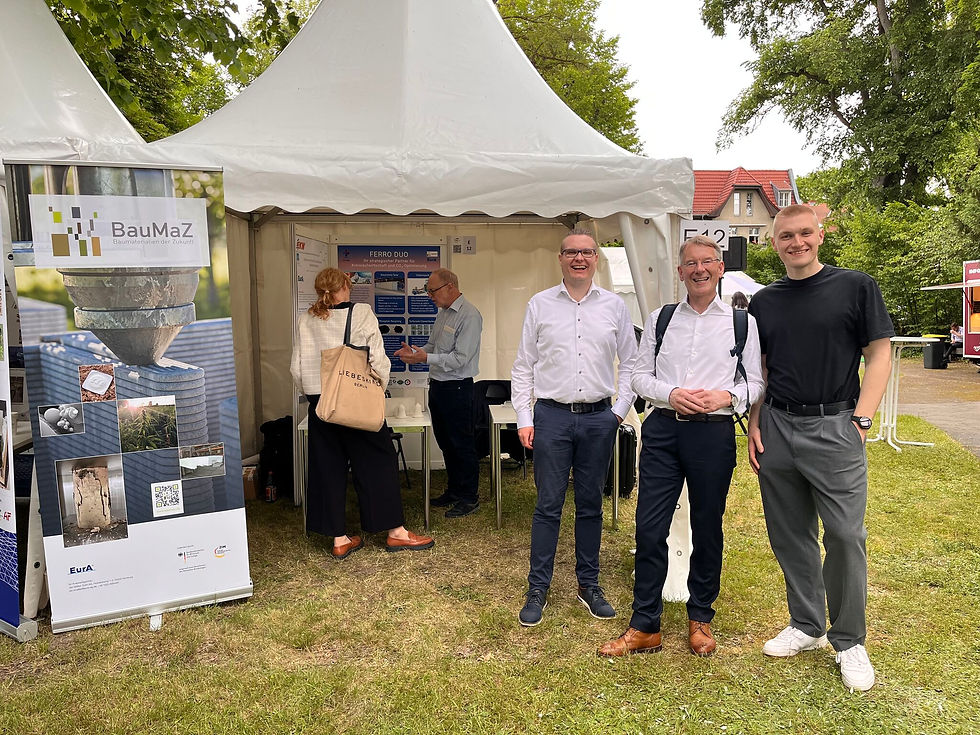 Jan Müller, Netwzerkmanager BauMaZ, mit zwei weiteren Personen vorm Ausstellungszelt
