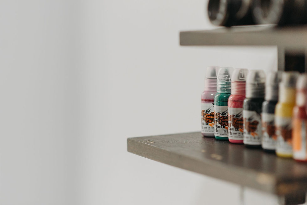 Colorful tattoo ink bottles arranged on a studio shelf