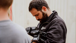 Kameramann fokussiert sich auf eine Detailaufnahme während einer professionellen Werbefilmproduktion.