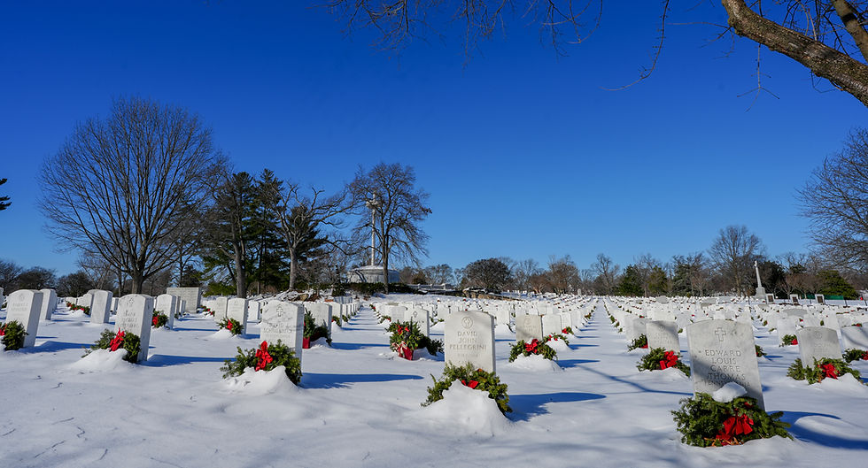 Tombstones covered in snow and decorated with Christmas wreaths at Arlington Cemetery