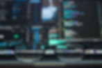 Glasses in foreground focus on laptop screen with colorful code and UI elements. Blurred background, tech workspace atmosphere.