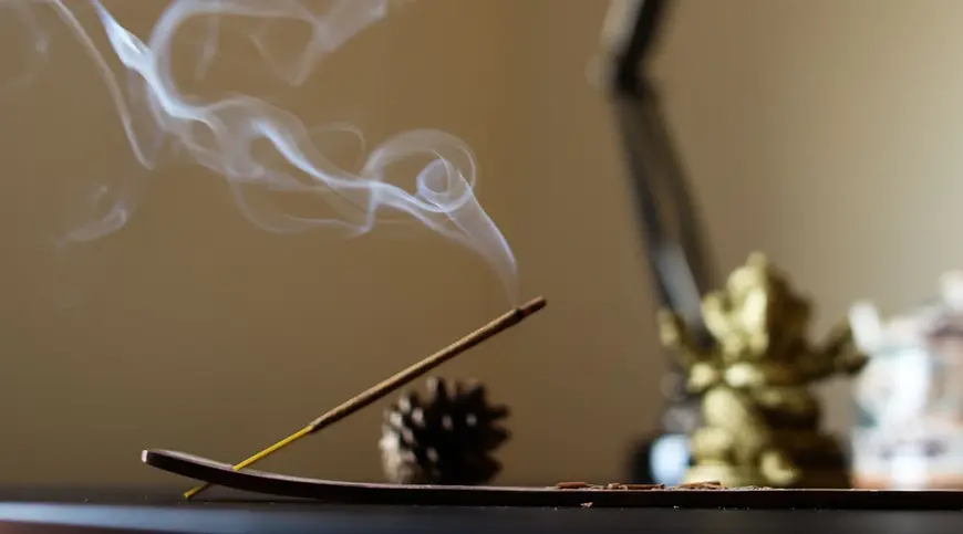 Incense_sticks_being_burned_using_incense_stick_holder.webp