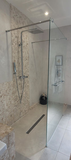 Mosaique en travertin et douche italienne en béton ciré
