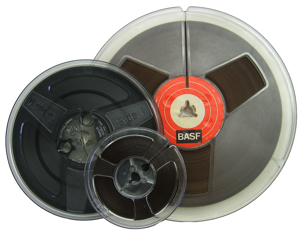 Three reel-to-reel tapes of varying sizes overlap. The largest has a red center labeled BASF. All tapes have brown film and clear rims.