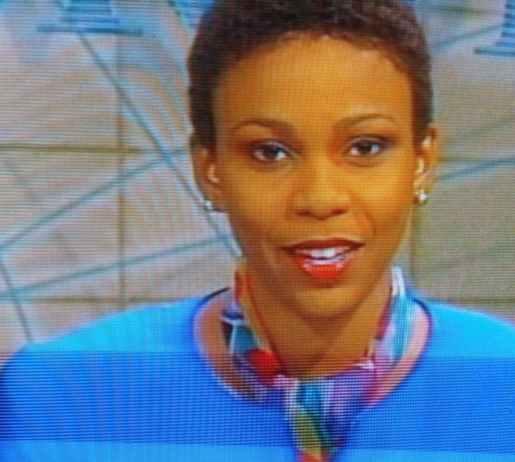 Helene Coley-Nicholson anchors the news dressed in a colourful scarf and a blue outfit.