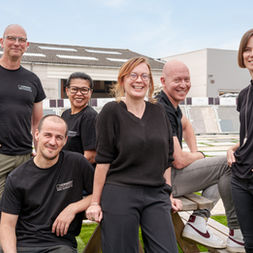 bedrijfsfotografie van team medewerkers in informele groepsopstelling buiten
