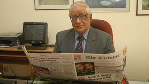 H K Dua reading The Tribune, with his favourite impressionist prints in the background. 