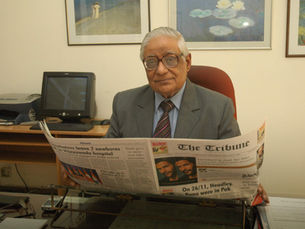 H K Dua reading The Tribune, with his favourite impressionist prints in the background. 