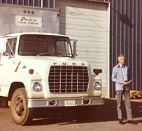 Founder, A.M. Dockery, standing beside a Dockery Floor Clovering Truck